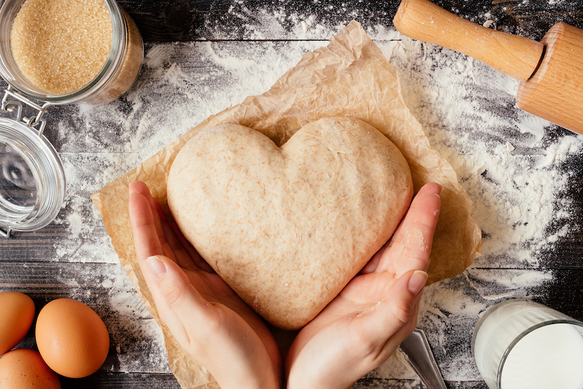 Photo of someone shaping baking dough into a heart.