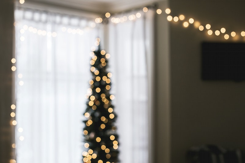 An unfocused image of holiday lights inside a home.